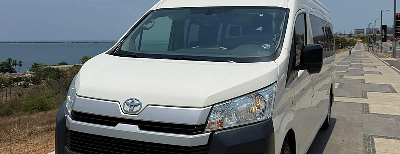 Toyota HiAce branca de 16 lugares da frota própria da Costa Phoebe, na marginal de Luanda