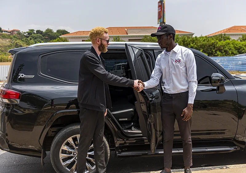 Costa Phoebe driver greeting a client beside a black Land Cruiser